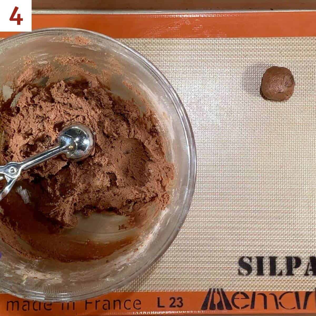 Portioning a scoop of cookie dough onto a baking pan.