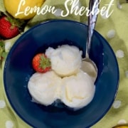 Lemon Sherbet scooped in blue bowl on green towel with strawberries & lemons from overhead Pinterest banner.