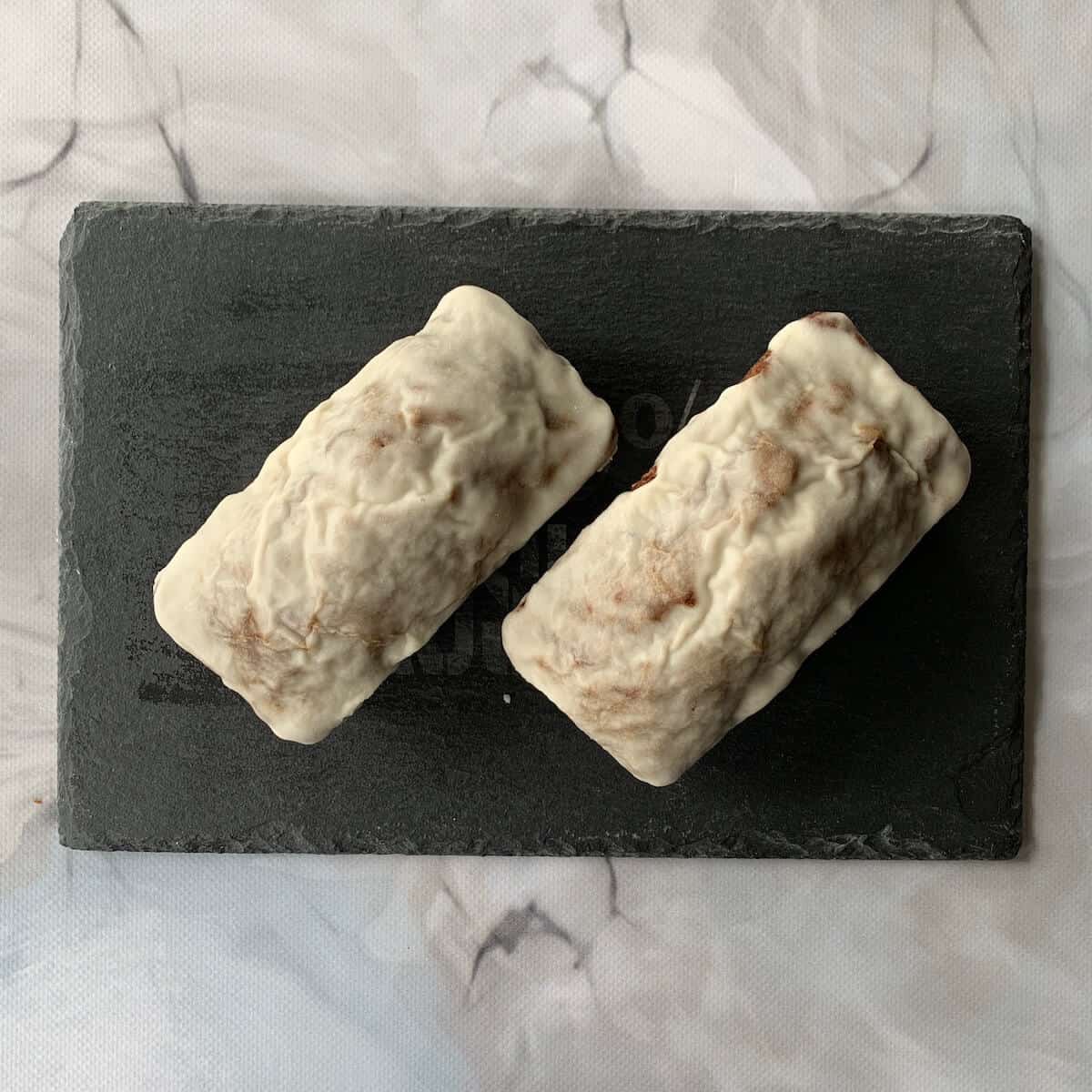 Two small Sourdough Banana Bread on slate from overhead.