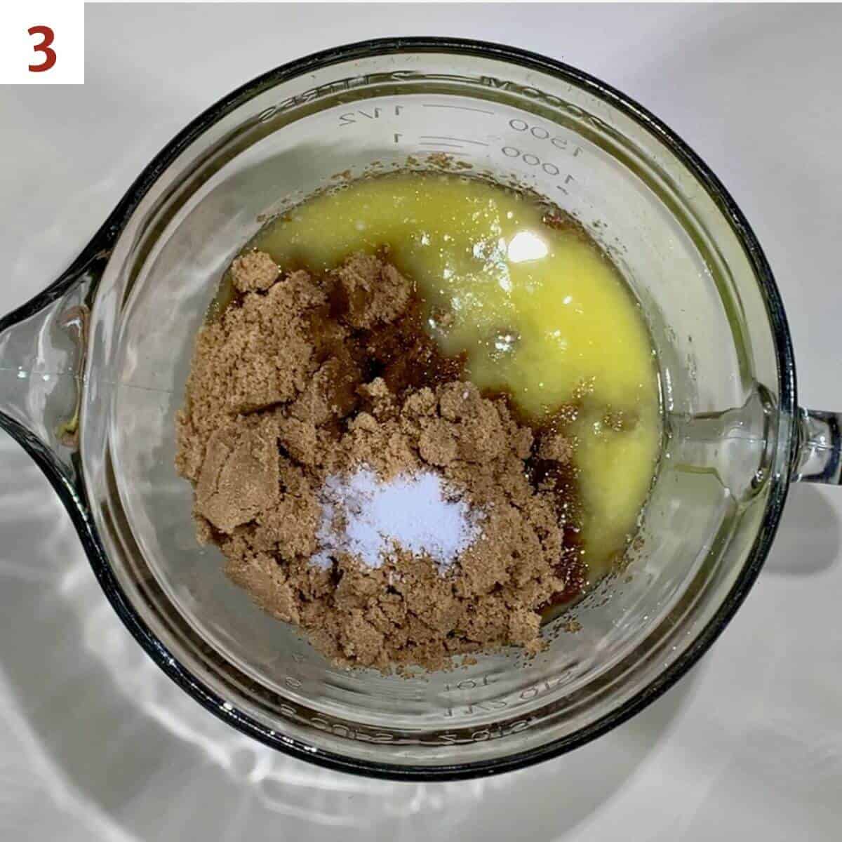 Eggs, brown sugar, melted butter, vanilla, and salt in a glass bowl from overhead.