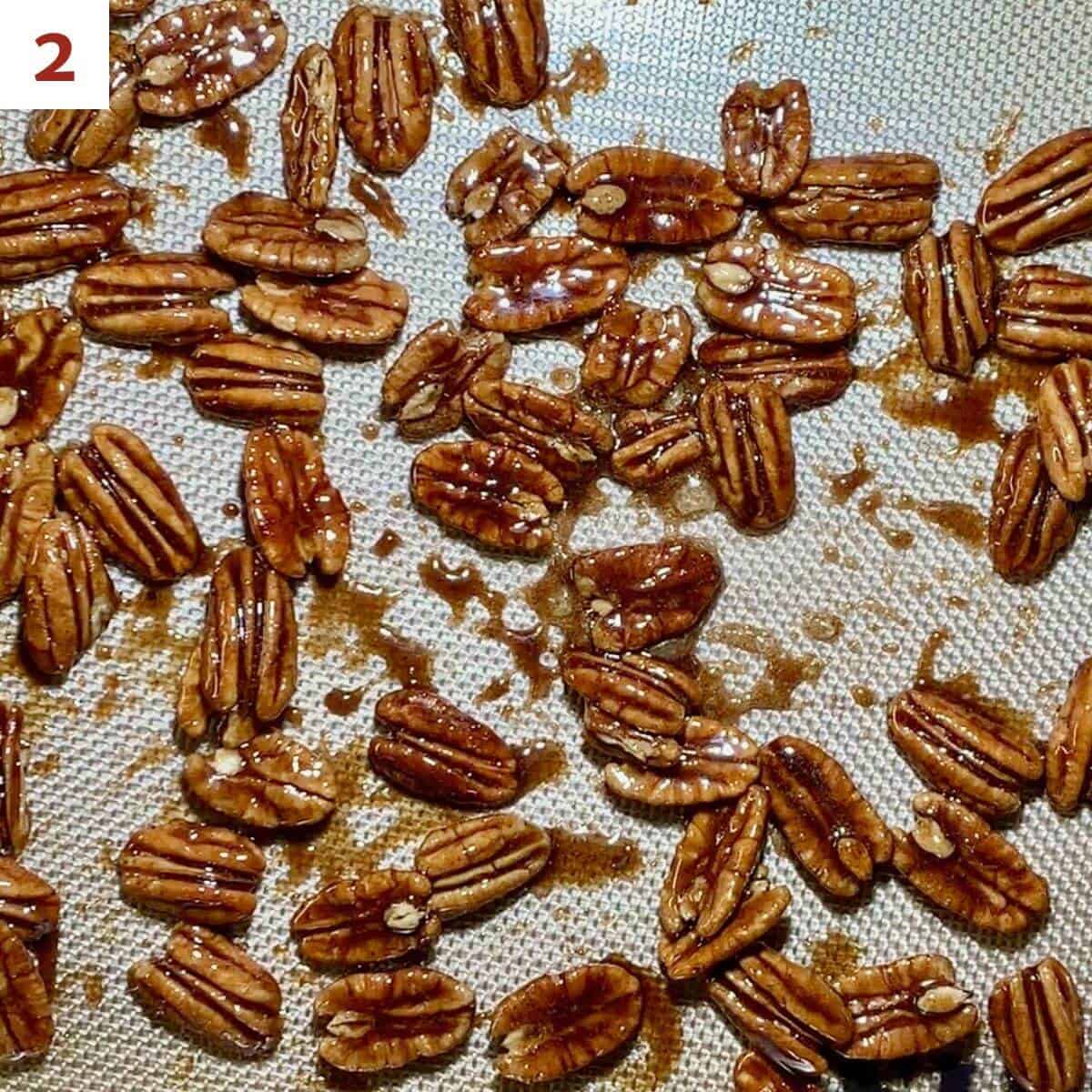 Candied pecans drying on a silicone mat.