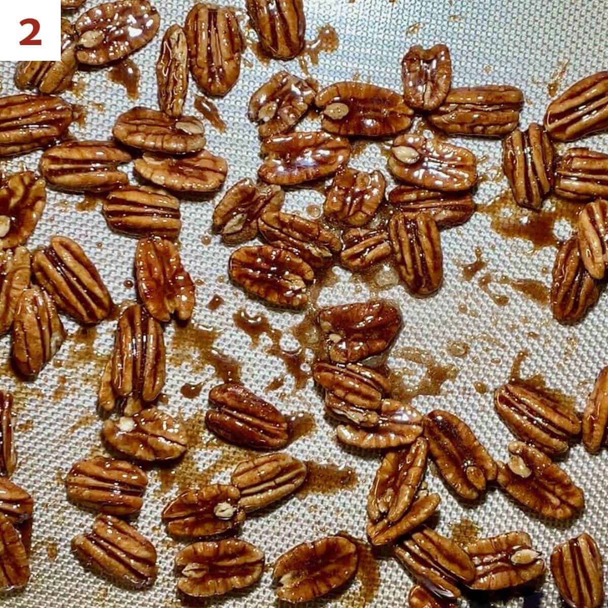 Candied pecans drying on a silicone mat.