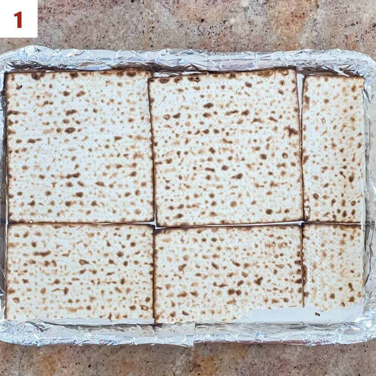 Laying out matzo on a foil-lined baking pan.