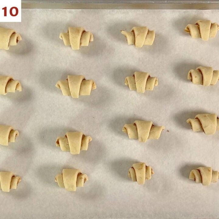 Shaped rugelach on a parchment-lined baking pan before freezing.