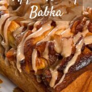 Whole apple honey babka on a plate on a honeycomb-decorated towel Pinterest banner.