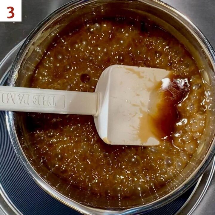 Adding vanilla to boiled butterscotch sauce in a saucepan.
