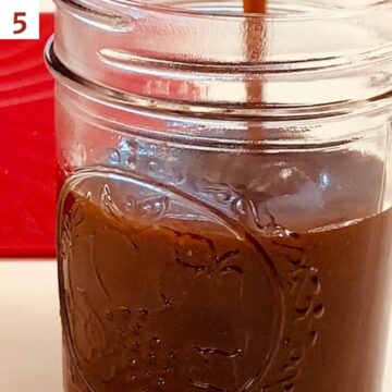 Caramel sauce being poured into a mason jar.