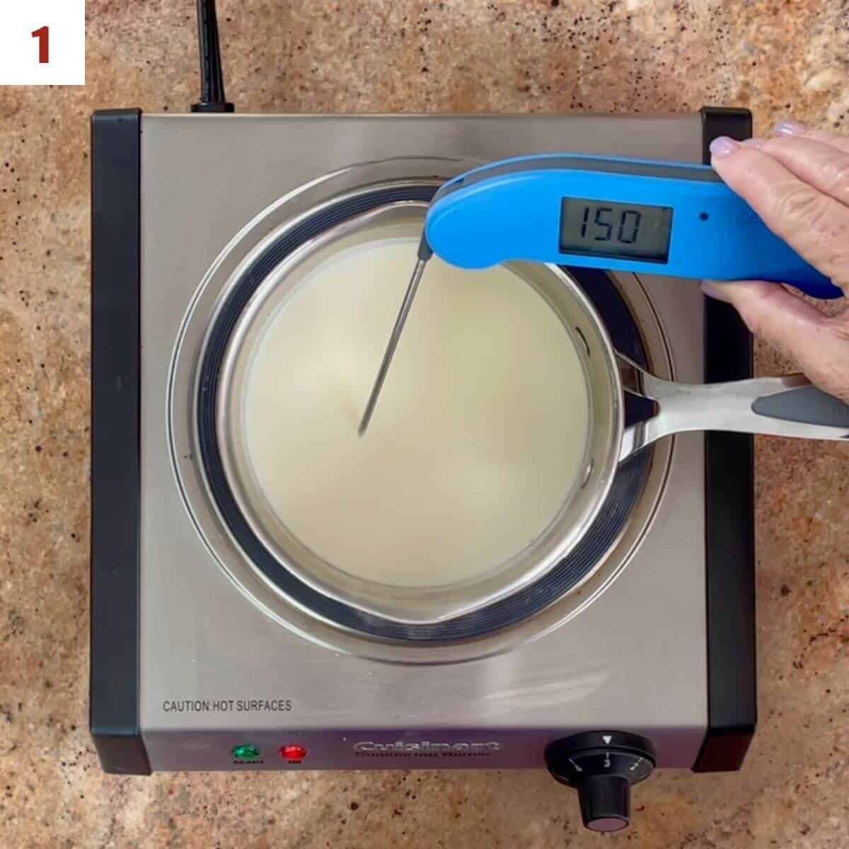 Using a digital thermometer to read the temperature of heavy cream in a saucepan on a hot plate.