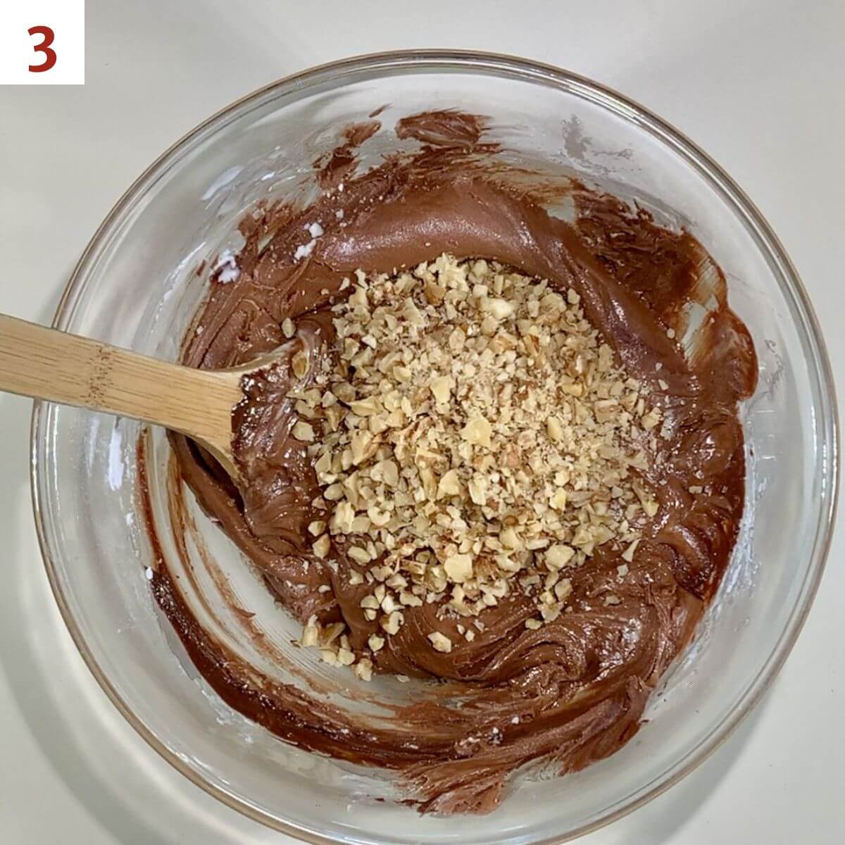 Mixing walnuts into whisky fudge in a bowl.