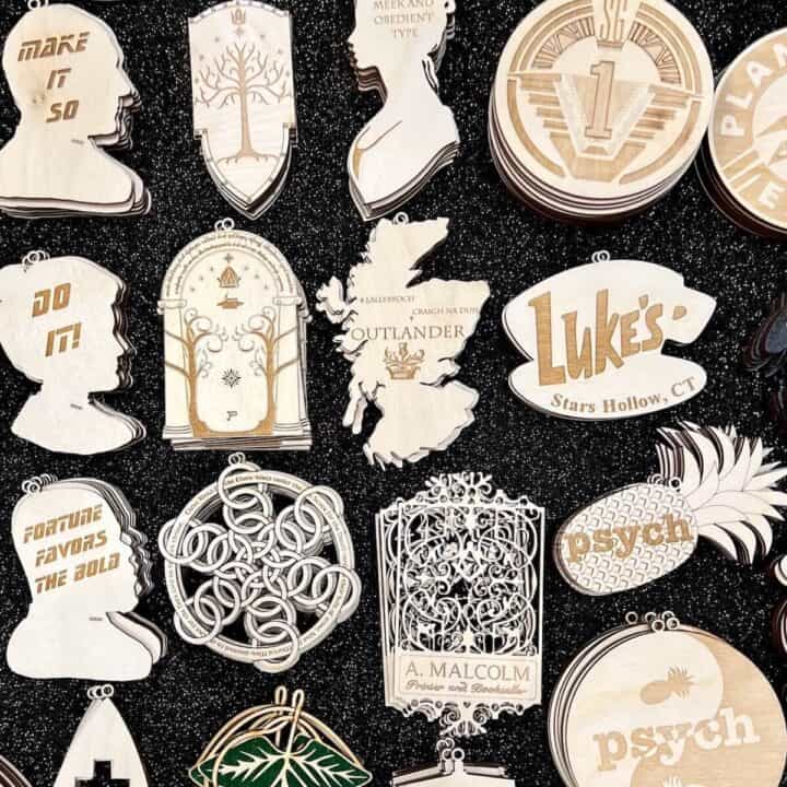 A display full of laser cut wooden ornaments from different fandoms, including Outlander.