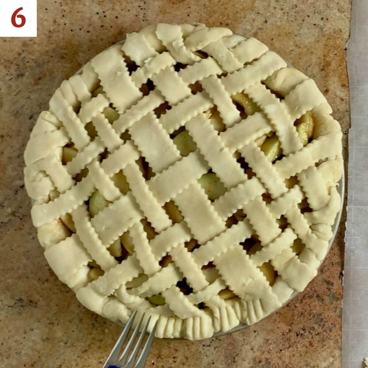 Crimping lattice pie crust edge with a fork.
