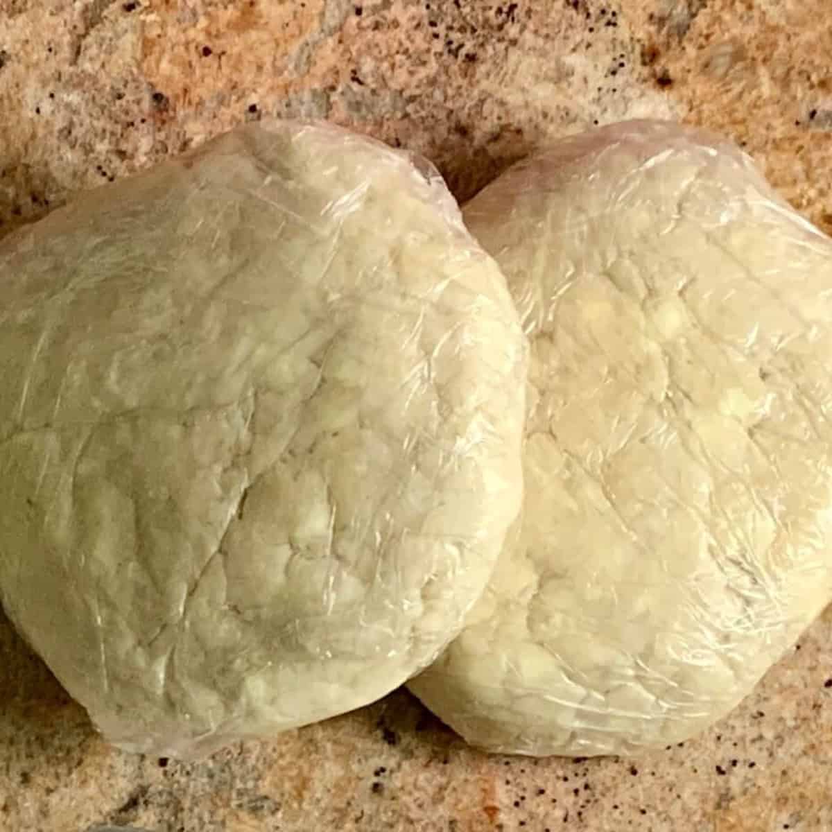 Two discs of all-butter pie dough wrapped in plastic.
