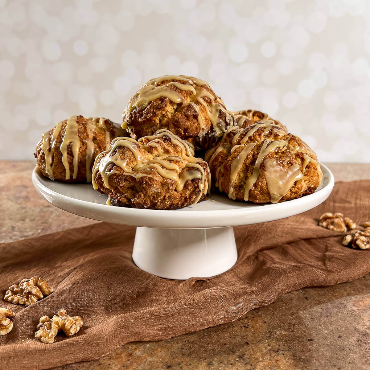 Maple Walnut Scones stacked on a white cake stand.