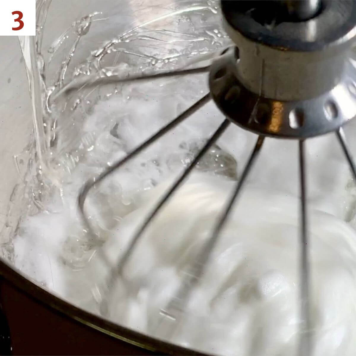 Pouring sugar syrup into meringue.