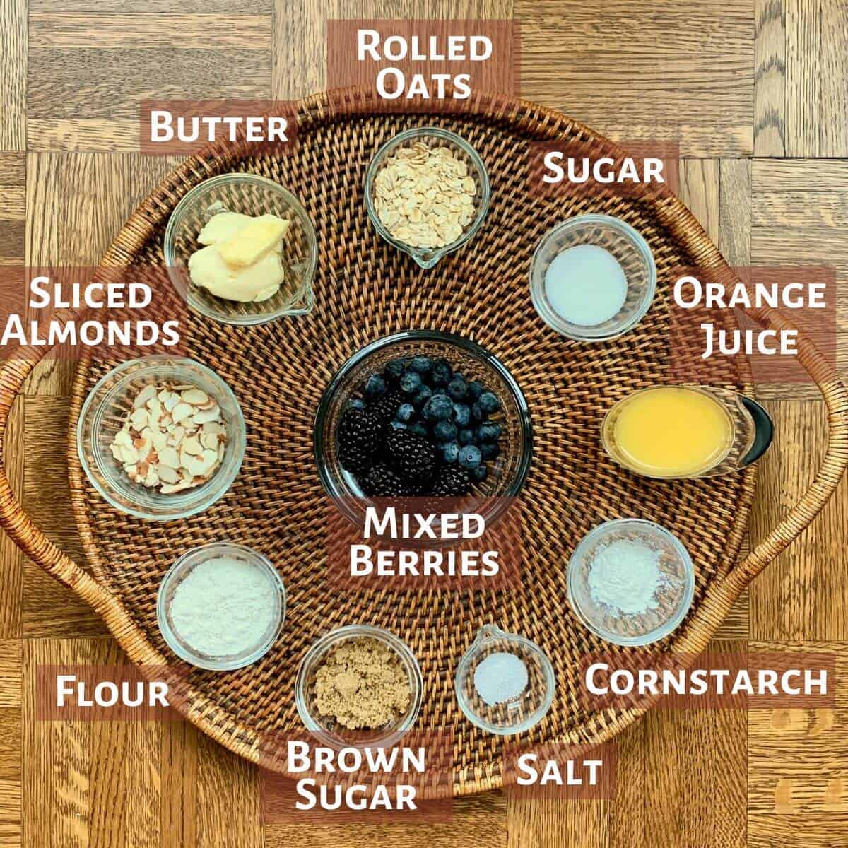 Skillet Berry Crisp portioned into glass bowls on a wooden tray.