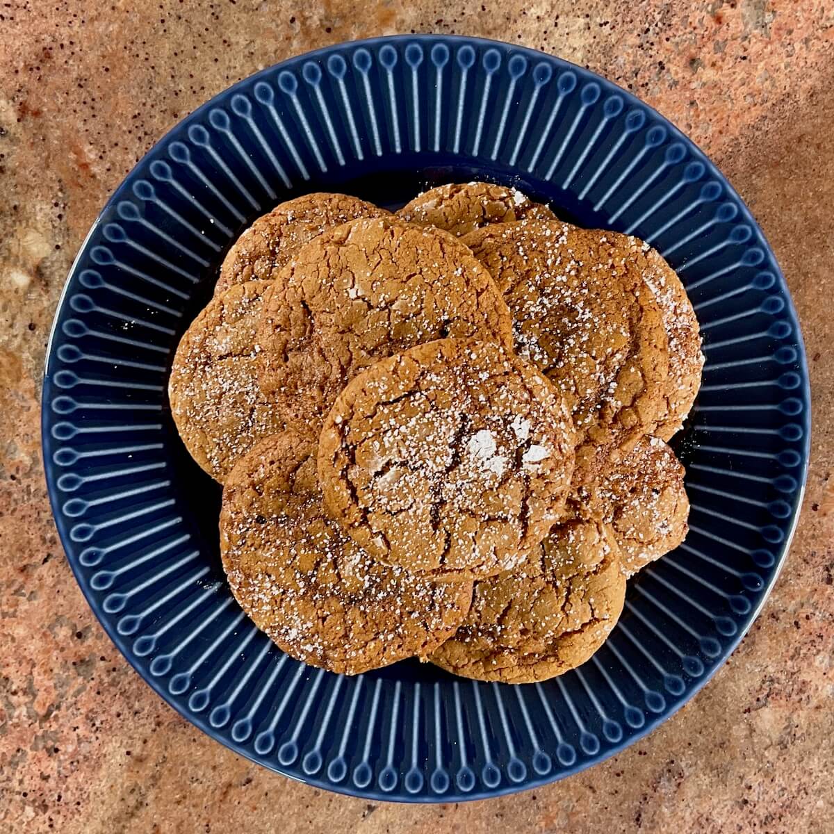 Molasses cookies on blue plate from overhead.