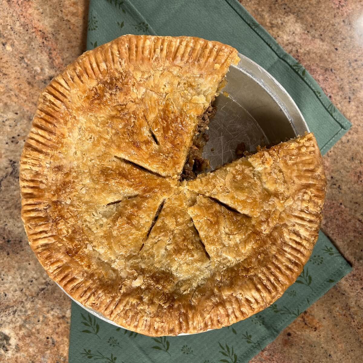 Baked Moroccan Beef Pie in the pan on a wooden table.