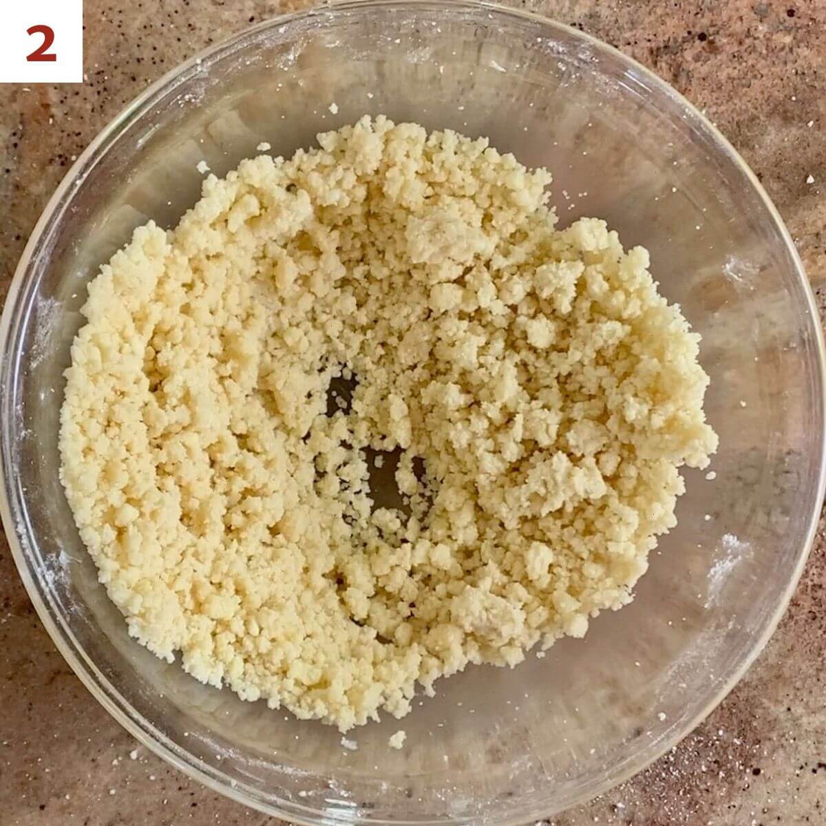 Shortbread dough in a glass bowl from overhead.