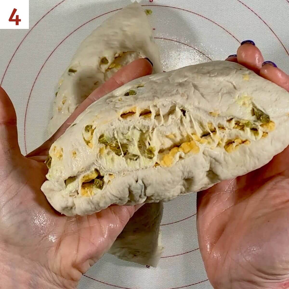 Displaying layers of bread dough stuffed with cheddar cheese & chopped jalapeños.