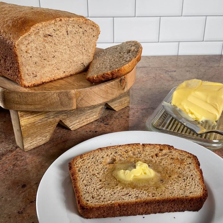 corned beef sandwich on sourdough rye bread, corn, and bread in backgroup