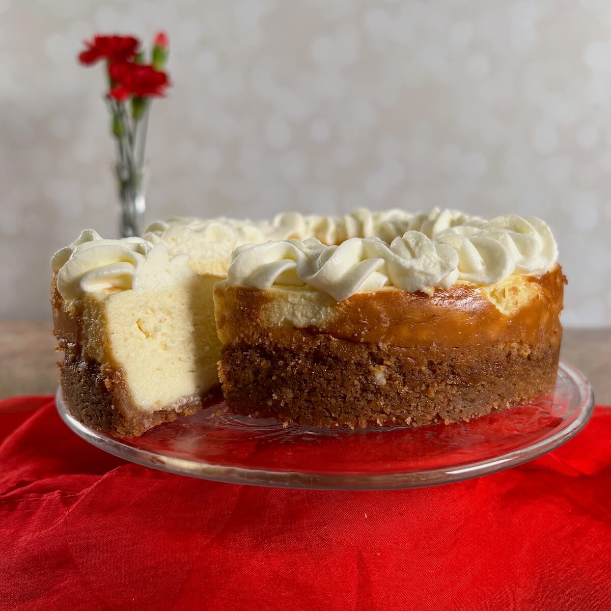 white wine cheesecake on cake plate with slice being lifted out.