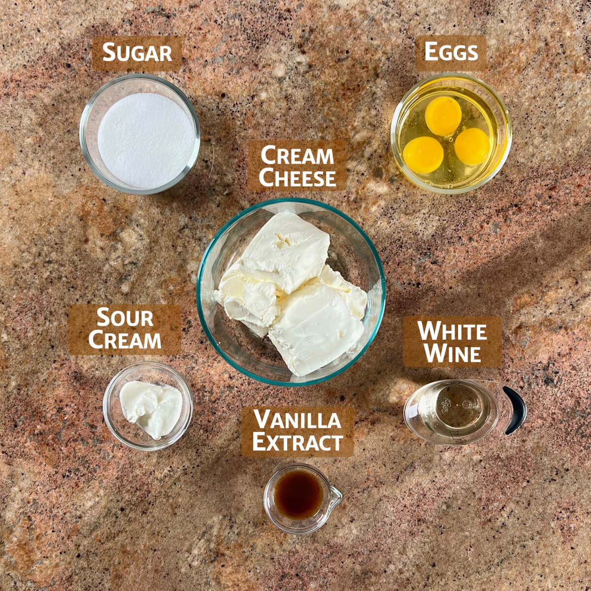 White wine cheesecake filling ingredients portioned into glass bowls.