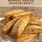 Mandel bread piled onto a white plate with a brown flowered edging Pinterest banner.