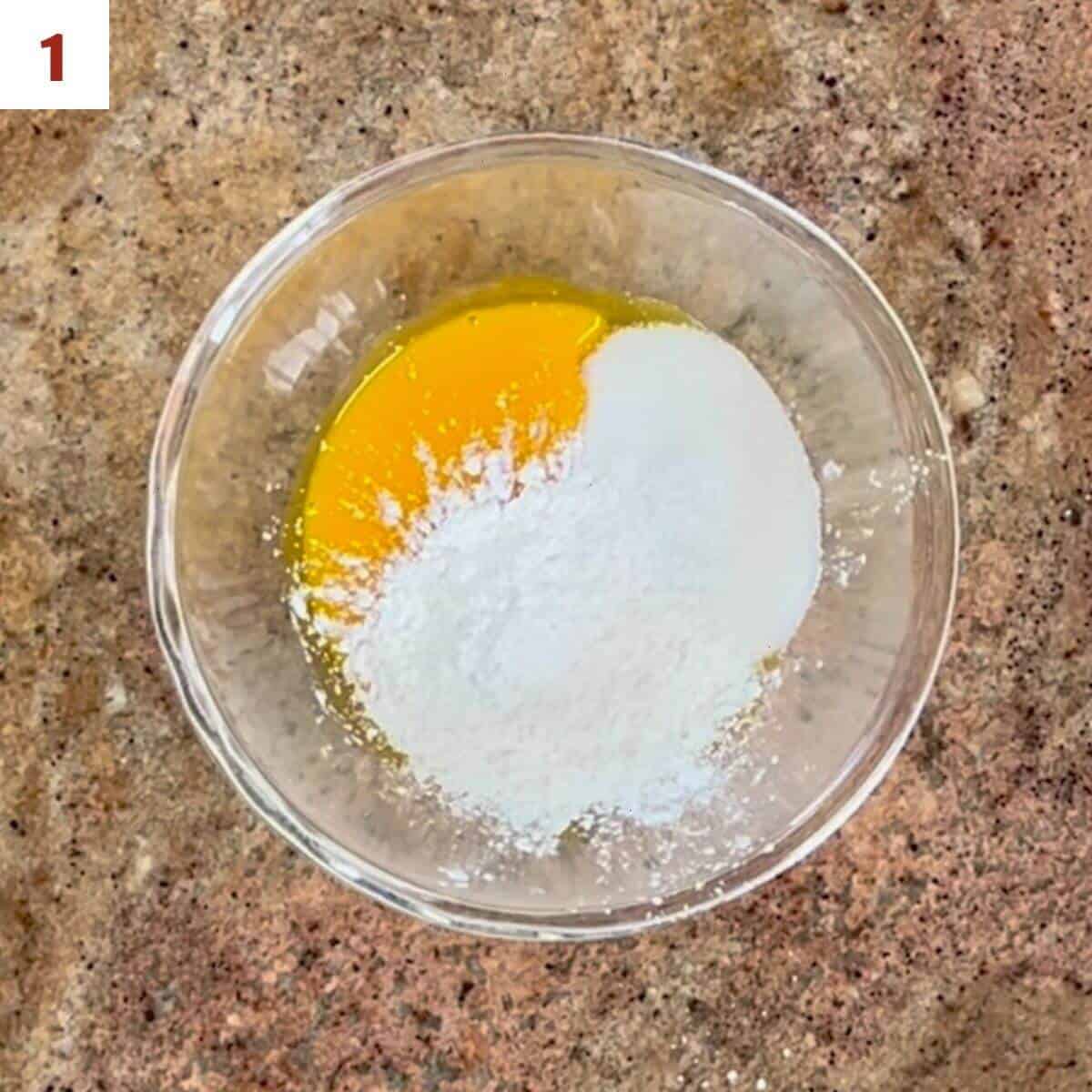Egg yolks, sugar, and cornstarch in a glass bowl from overhead.