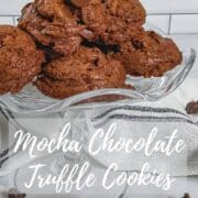 Mocha Chocolate Truffle Cookies stacked on a glass cake stand surrounded by a white towel with a blue stripe & chocolate chips Pinterest banner.