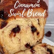 Sliced cranberry cinnamon swirl bread on a white plate viewed from the side Pinterest banner.