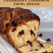 Sliced cranberry cinnamon swirl bread on a white plate viewed from the side Pinterest banner.