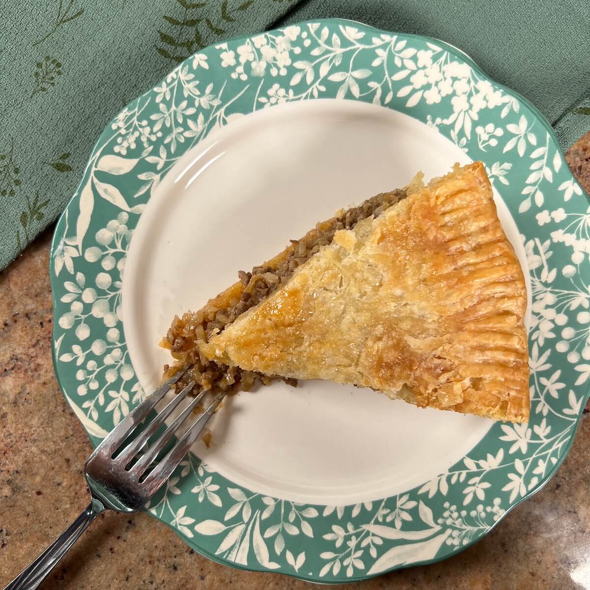 Slice of Moroccan Beef Pie on a plate with a fork.