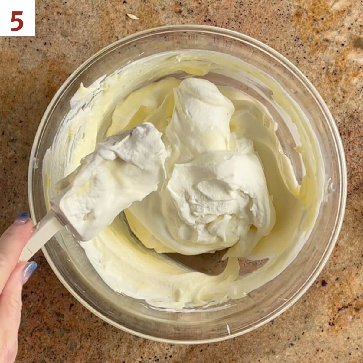 Folding the whipped cream into the mascarpone cream mixture.