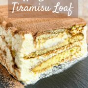 Sliced end of a loaf of Tiramisu on a black platter pinterest banner.