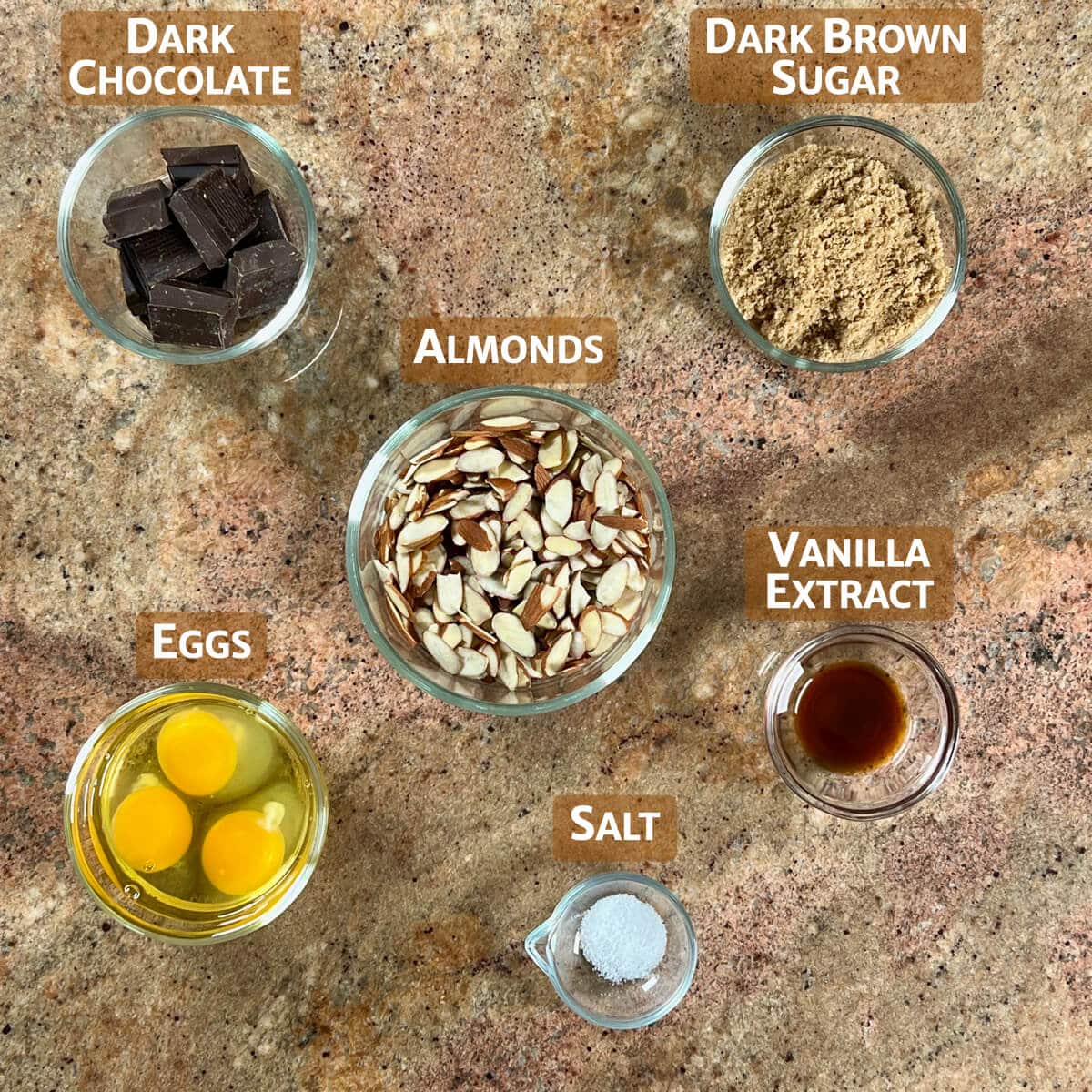 Ingredients for Flourless Chocolate Almond Cake portioned into glass bowls.