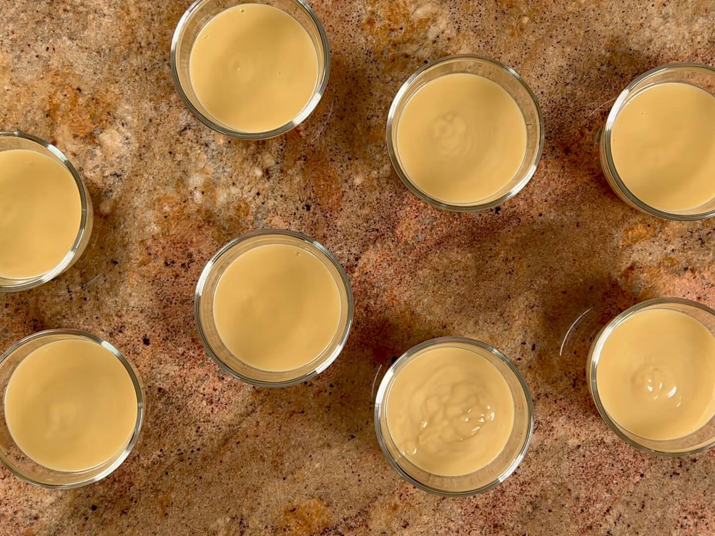 Eight servings of maple pudding in small bowls.