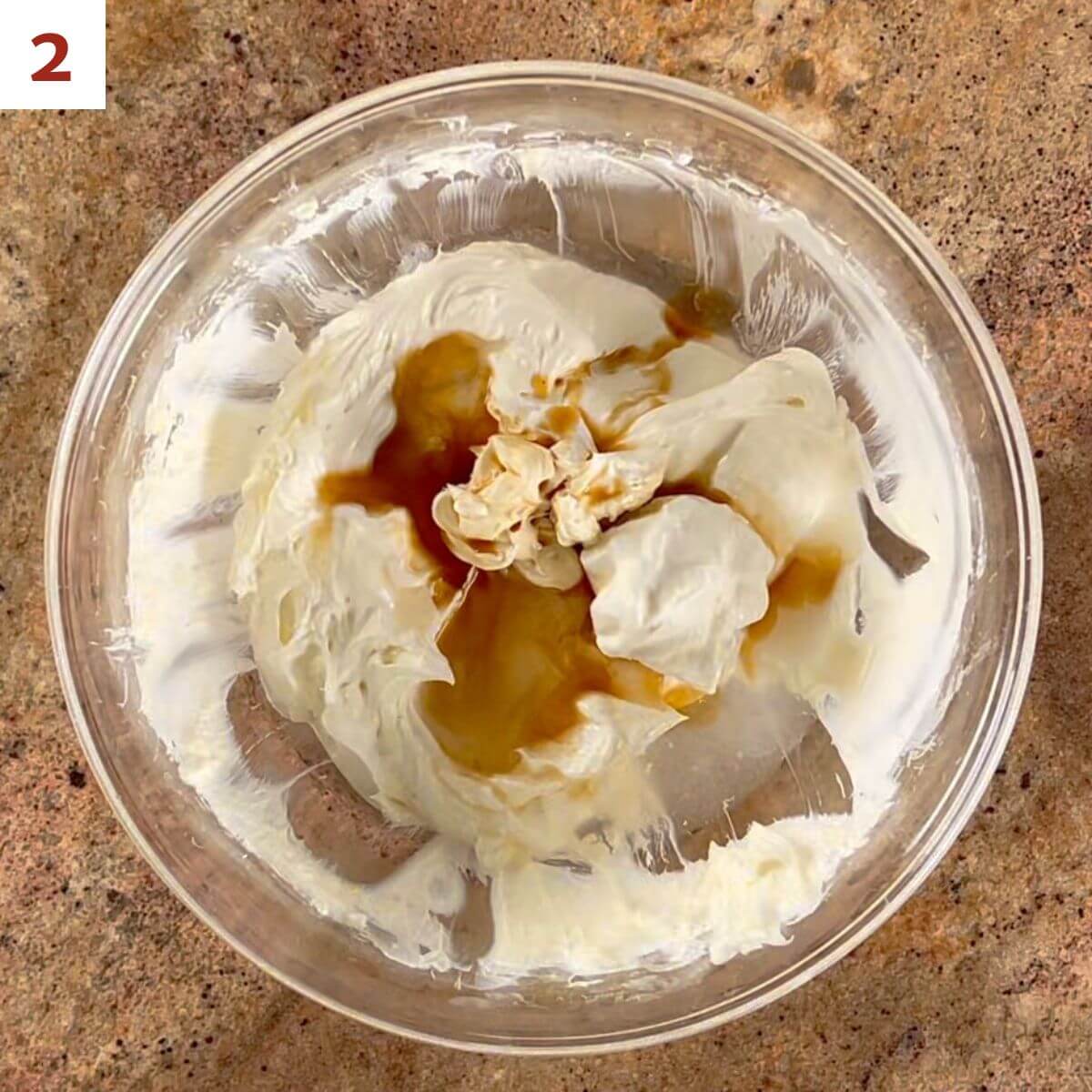 Mixing the sour cream, white wine, and vanilla into the cream cheese mixture.