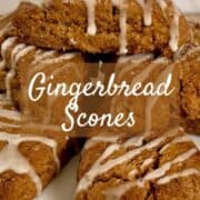 Gingerbread scones piled on a white cake stand on a green plaid towel Pinterest banner.