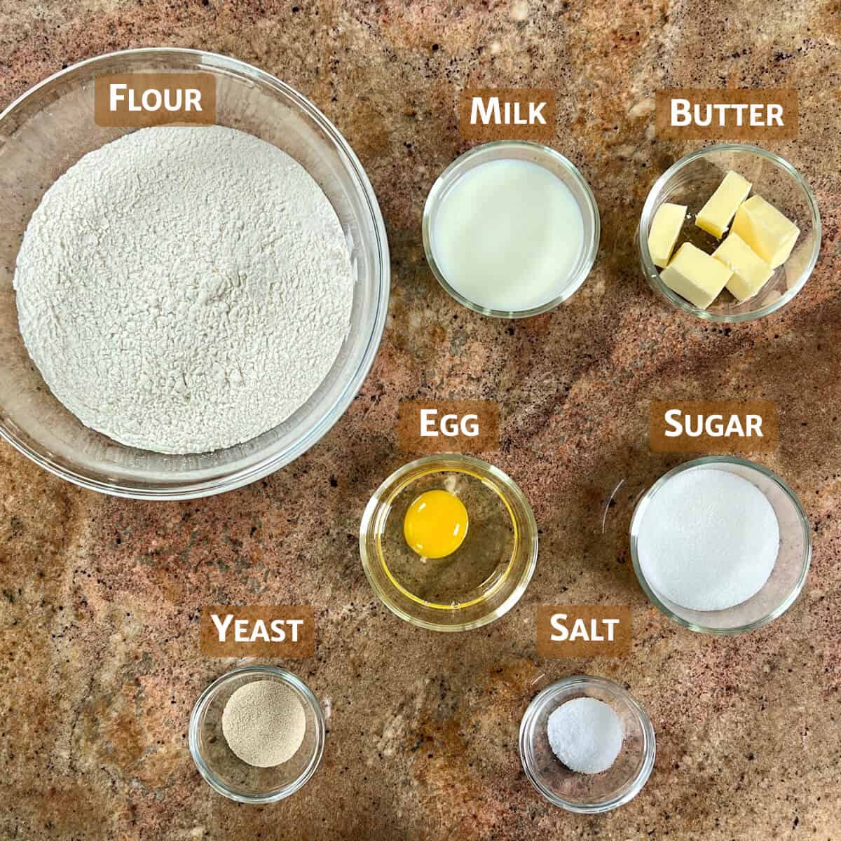 Ingredients for cream bun dough portioned into glass bowls.