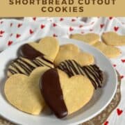 Heart shaped shortbread cutout cookies stacked on a white plate Pinterest banner.