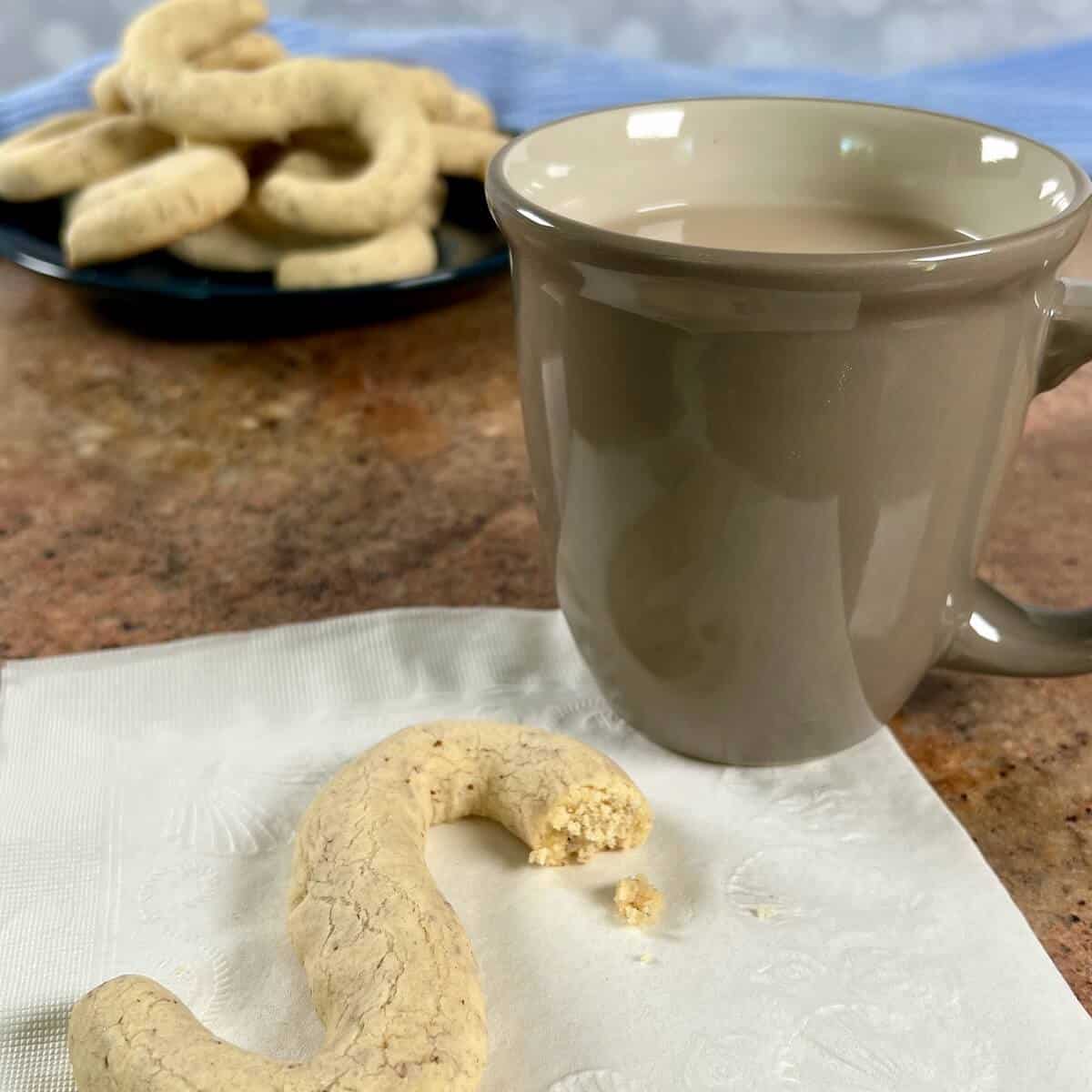 A cup of coffee and a cookie on a napkin
