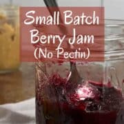 Mixed berry jam in a jar with a spoon inside Pinterest banner.