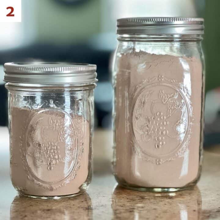 Two containers of hot cocoa mix in a pint and quart canning jar.