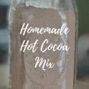Two containers of hot cocoa mix in a pint and quart canning jar Pinterest banner.
