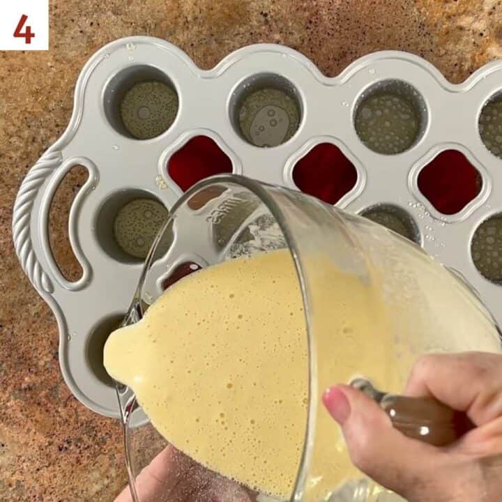 Pouring popover batter into the greased popover pan.