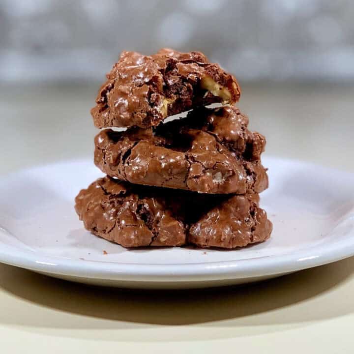 Three Flourless Chocolate Walnut Cookies on a white plate.