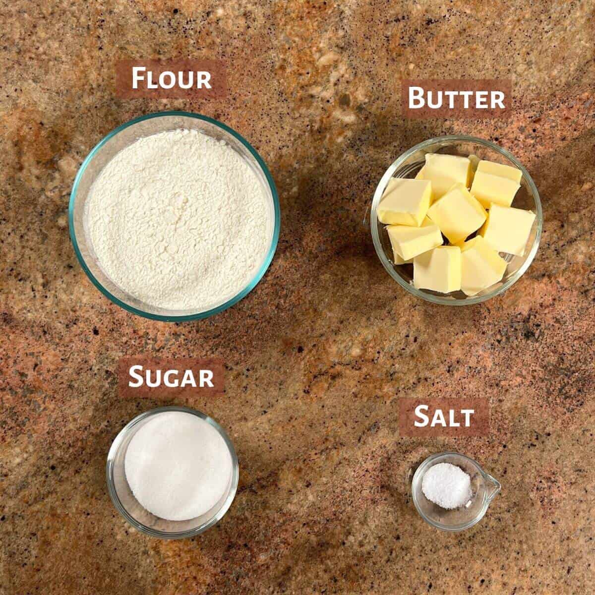 Ingredients for shortbread portioned into glass bowls.