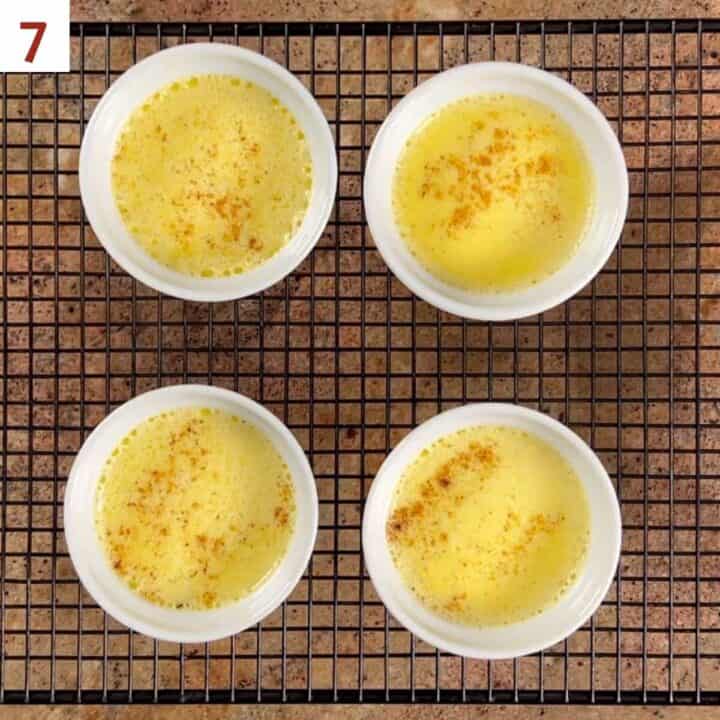 Four baked egg custard ramekins ona cooling rack.