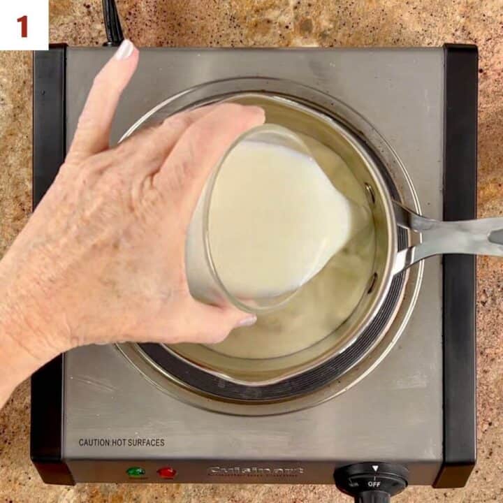 Pouring milk into a saucepan with heavy cream on a hot plate.