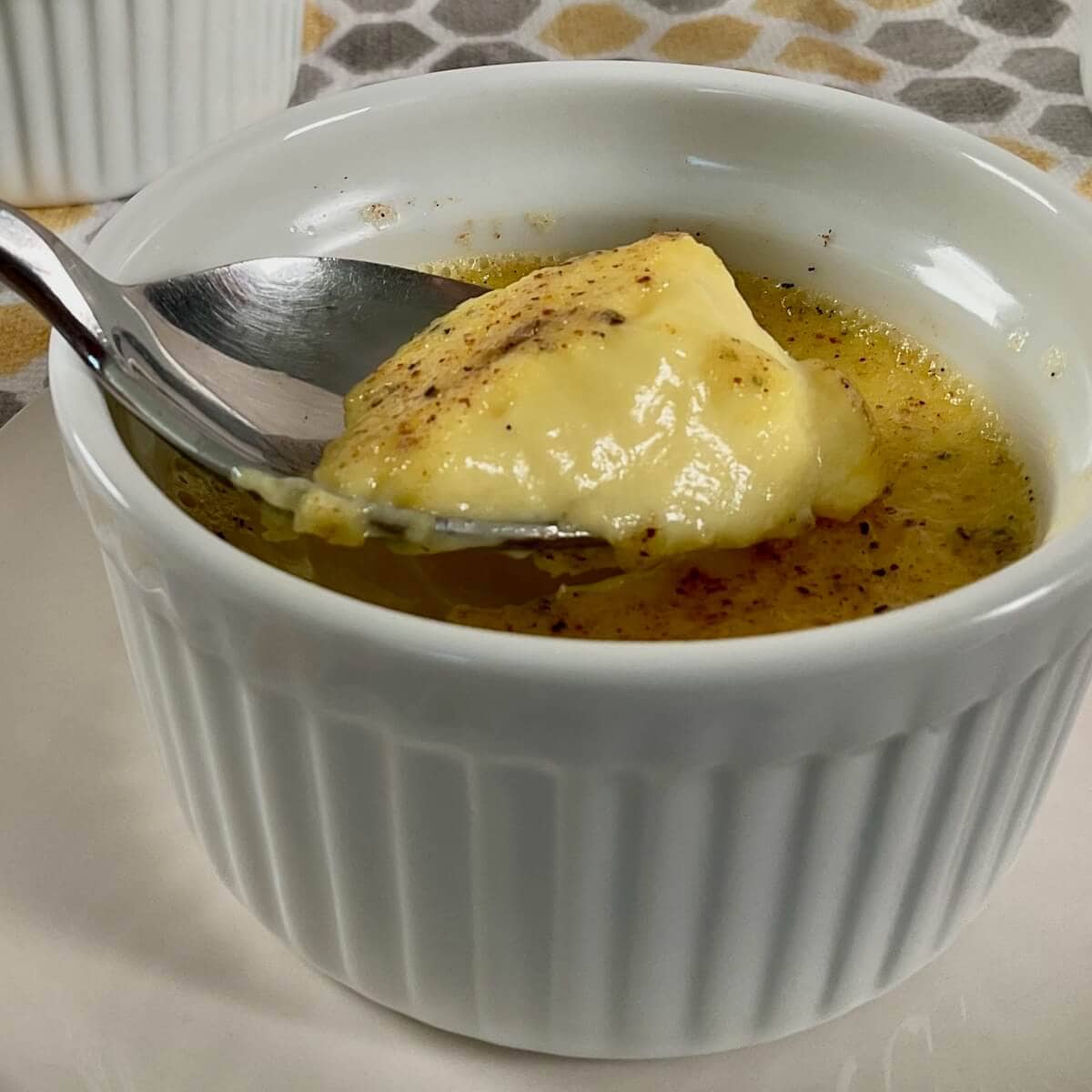 Egg custard with a spoon lifting out some of the custard.